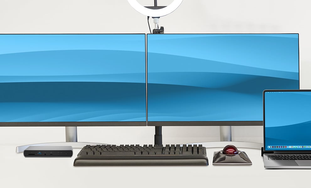 Macbook yhdistettynä useisiin Kensigton-laitteisiin ja kahteen näyttöön.