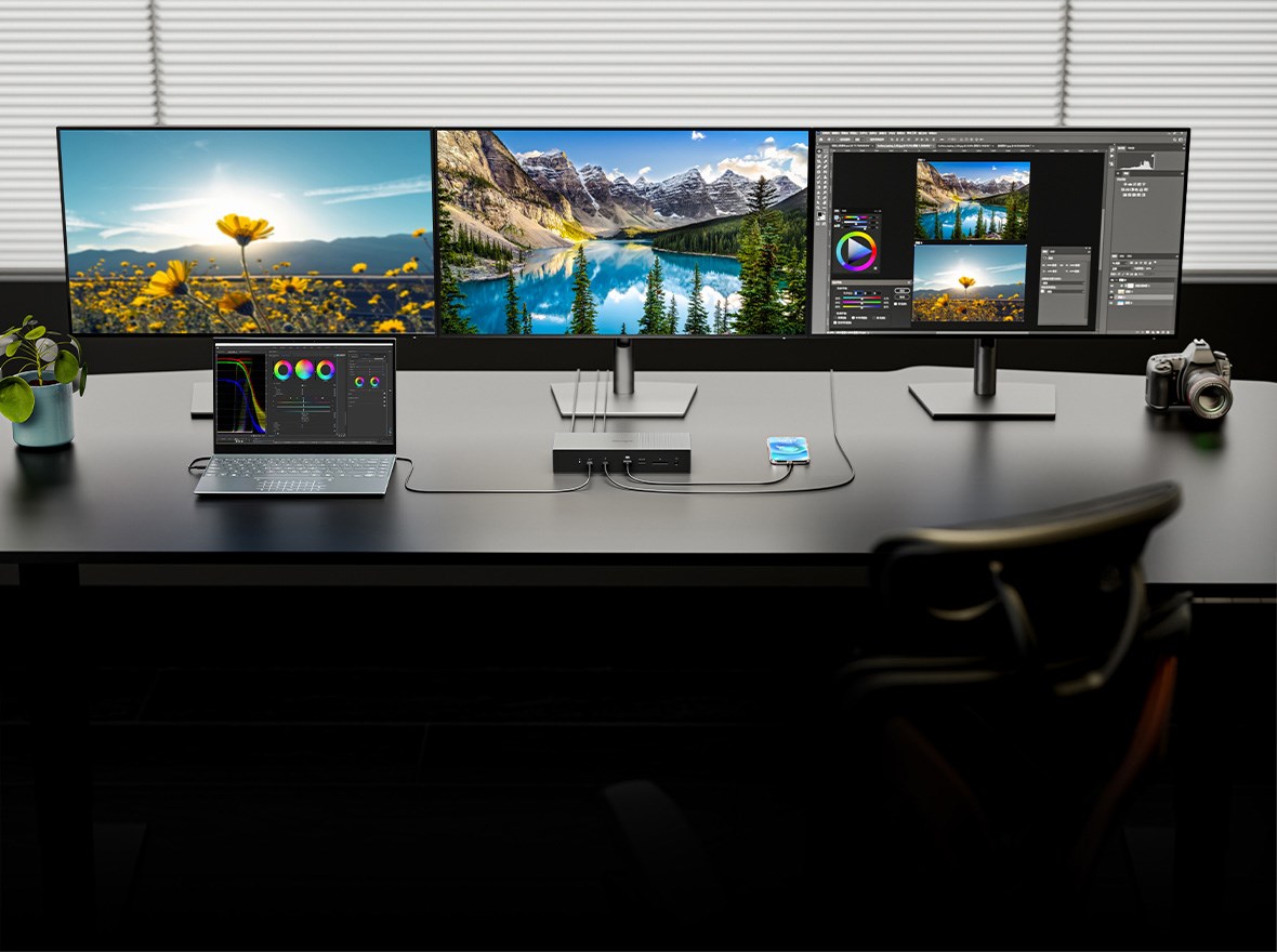 Una configuración de varios monitores para un profesional, equipada con tres pantallas 4K, un portátil, una tableta, una cámara y un replicador de puertos SD5000T5 EQ Thunderbolt 5 de Kensington.
